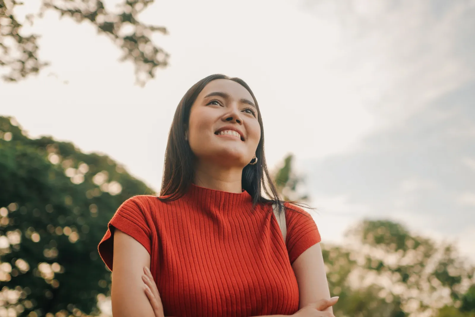 Young woman in a red top smiling outdoors